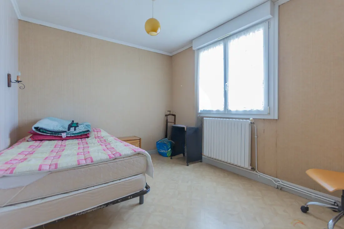 Chambre avant rénovation avec papier peint beige, ancien sol et mobilier simple