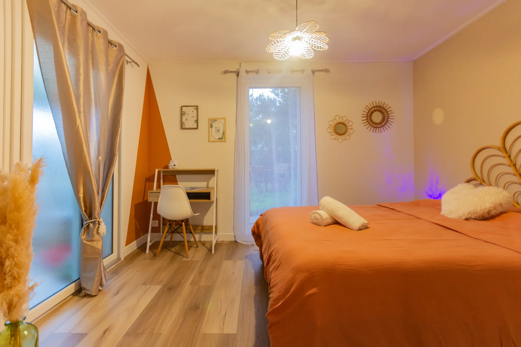 Chambre après rénovation avec sol bois, teintes chaudes et coin bureau aménagé